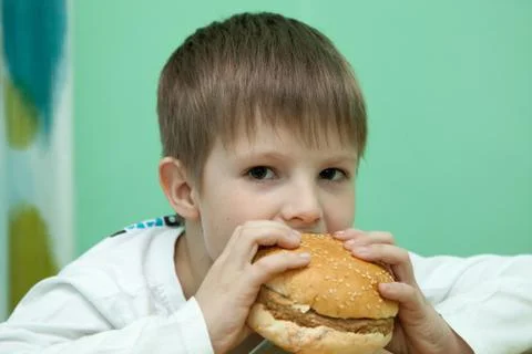 Boy with burger Stock-Fotos