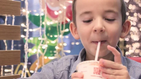 A boy in a cafe  drinking a beverage through a straw Stock Footage 122937123