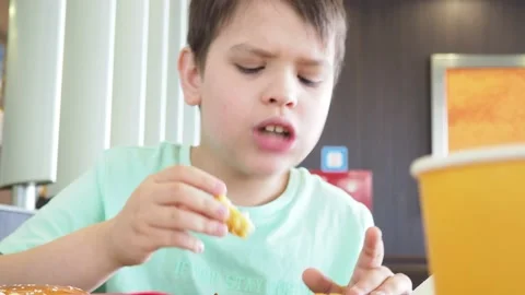 Boy in a cafe eats fast food. junk food. nuggets with sauce. like food. Vídeos de archivo 167212420