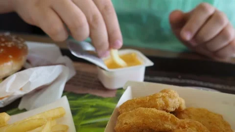 Boy in a cafe eats fast food. junk food. nuggets with sauce. like food. Vídeos de archivo 167212428