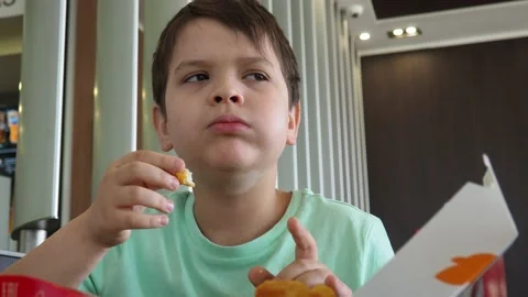 Boy in a cafe eats fast food. junk food. nuggets with sauce. like food. Vídeos de archivo 167212497