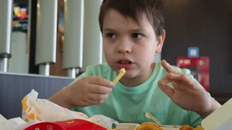 Boy in a cafe eats fast food. junk food. nuggets with sauce. like food. Vídeos de archivo 167212547