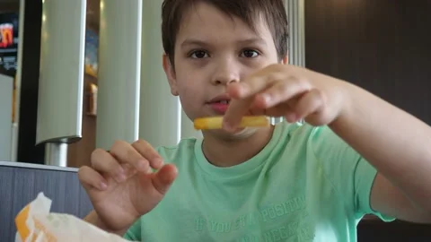 Boy in a cafe eats fast food. junk food. nuggets with sauce. like food. 스톡 동영상 167212553