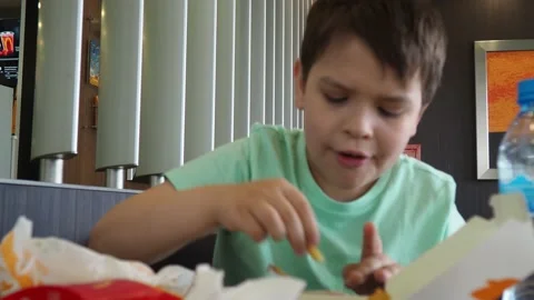 Boy in a cafe eats fast food. junk food. nuggets with sauce. like food. Vídeos de archivo 167212568