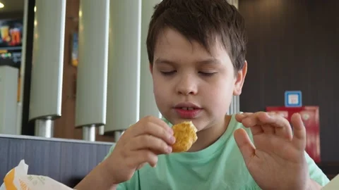 Boy in a cafe eats fast food. junk food. nuggets with sauce. like food. Vídeos de archivo 167212569