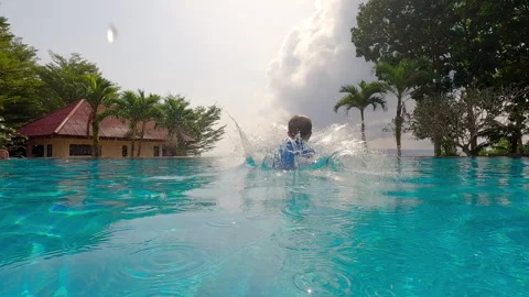 Boy Cannonball Jumps In Infinity Pool 動画素材 244744684