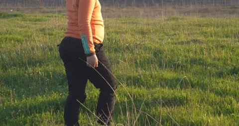 The boy in a cap goes on the green grass in the rays of sunset Stock-Footage 88426501