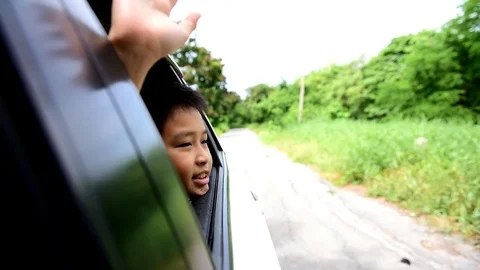 Boy in car waving hand Stock Footage 77631778