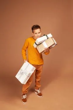 The boy carries three large boxes with gifts Stock Photos