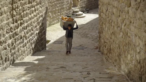 Boy carrying a basket full of bread, October 23, 2023 Mardin Turkey, se01 Stock Footage 277041057