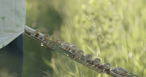 Boy carrying flute through grass field Stock Footage 188678951