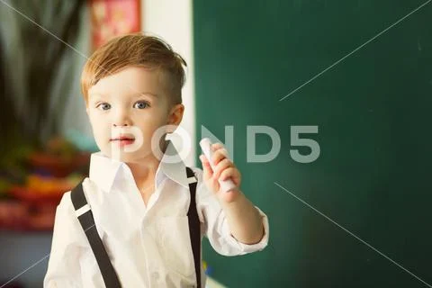 Boy with chalk over green chalkboard. Preschool or school concept ~ Hi ...