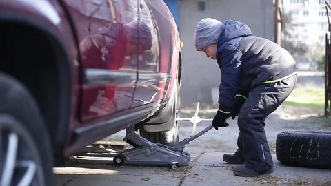 The boy changes the wheel. Stock Footage 130002094