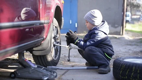The boy changes the wheel. Stock Footage 130002142