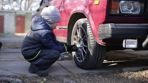 The boy changes the wheel. Stock Footage 130002144
