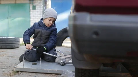 The boy changes the wheel. Stock Footage 130002340