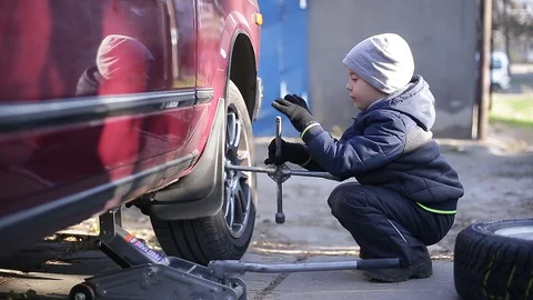 The boy changes the wheel. Stock Footage 130002506