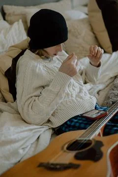 Boy changing guitar strings on bed Stock Photos