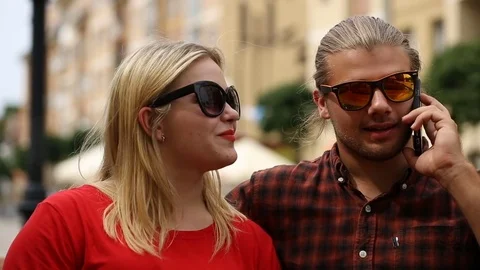 Boy chatting on cellphone while sitting with his girlfriend in the restaurant Stock Footage 77476910