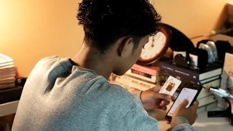 A boy is checking gold price charts on a smartphone Stock Footage 321691689