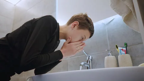 Boy checks mirror then washes hands, LED backlight and vanity frame, steady Stock-Footage 334789916