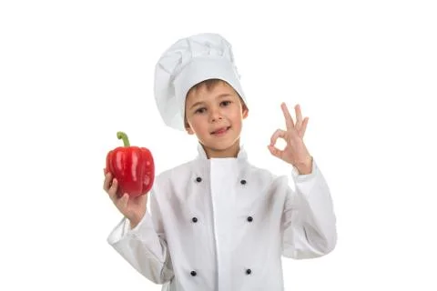 Boy in chef uniform making ok gesture and holding red pepper Stock Photos