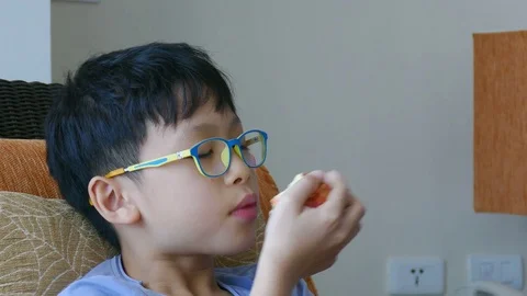 Boy is chewing an apple Stock Footage 75674402