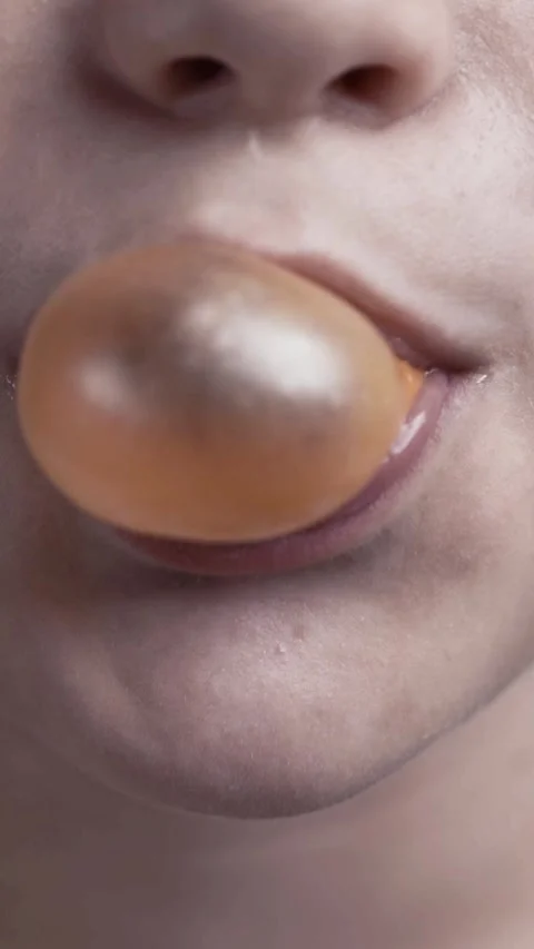 Boy chews gum and blows a large translucent bubble. Stock Footage 344768275