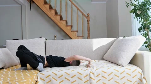 Boy child does on head gymnastic bridge exercises in the room on bed Stock Footage 171576689