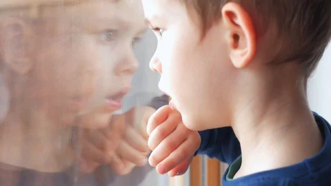 Boy, child looking through window glass Stock Footage 87124244