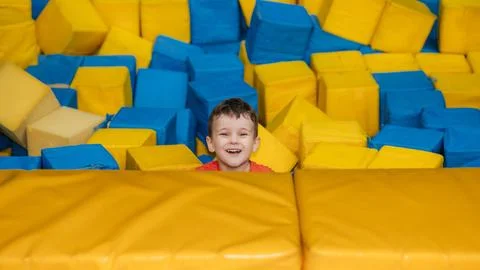 A boy child plays in a pool with soft cubes,. A child in a game entertainment Stock Photos