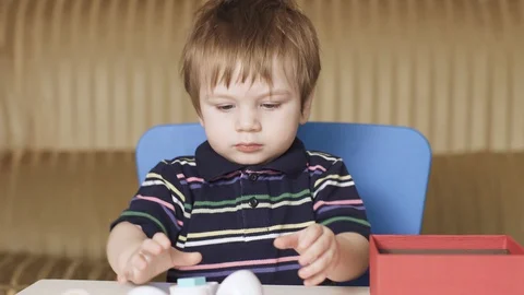 Boy child plays a puzzle Video stock 129952432