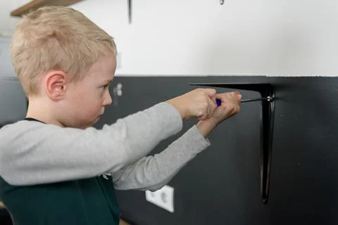 Boy child using screwdriver at home Stock Photos
