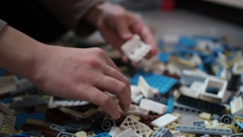 The boy chooses the items from the scattered surface Stock Footage 146976737