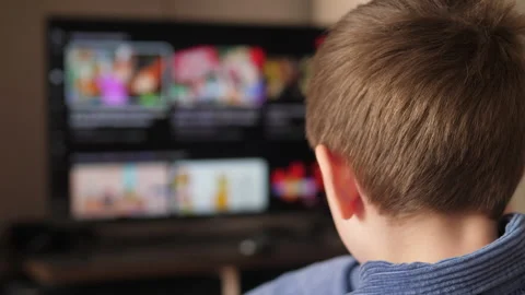 The boy chooses programs channels flipping through the pages on the smart t.. Stock Footage 241580965