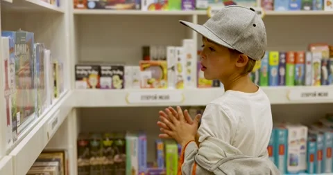 Boy choosing between board games in toy store Stock-Footage 294673821