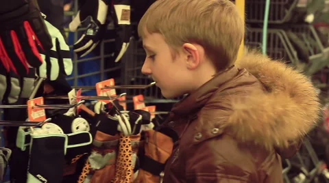 Boy choosing gloves in the store Stock Footage 57508826
