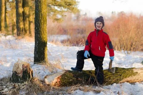 Boy chopping wood in the winter on the nature Stock Photos