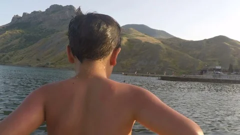 The boy with a circle jumps into the water Stock-Footage 79479002