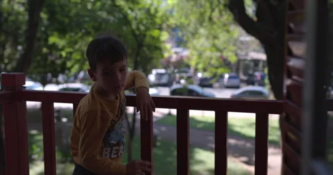 Boy on city balcony comes inside house - urban child Stock Footage 320923318