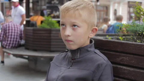 A boy in the city on a bench Stock Footage 271051563