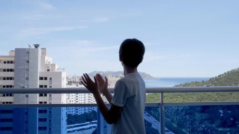 Boy clapping hands, waving hand, greeting with neighbours. Applauding from Stock Footage 129707910