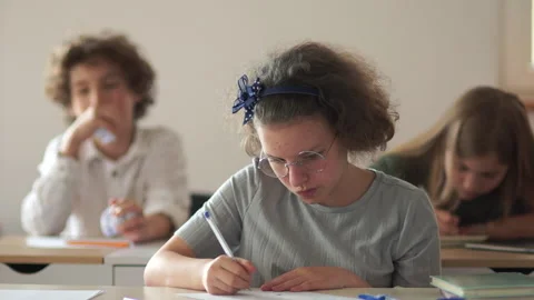 A boy in a class throws paper at a girl, offends and humiliates a classmate, a Stock Footage 132427045