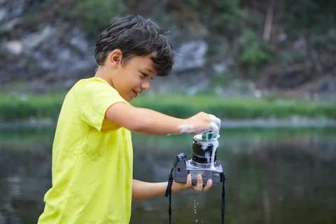 Boy cleans camera with foam. Stock Photos