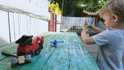 The boy cleans the table with a brush. Drawing, chalk, learning, interest, hobby Stock Footage 276575614