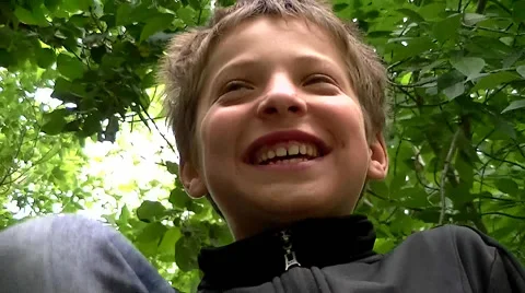 Boy climbed a tree and laughs Stock Footage 64165727