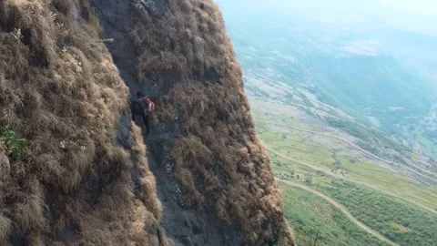 A Boy climbing on dangerous mountain view from air with drone camera. Stock Footage 286730837