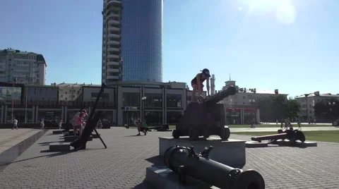 Boy is Climbing on a Monument of Machine Gun in Squer in Summer Vacation Stock Footage 65194379