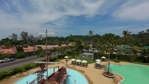 Boy climbing on a pirate ship structure in a resort pool Video stock 306660235