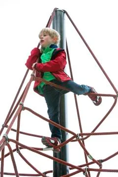Boy climbing on playground Stock Photos